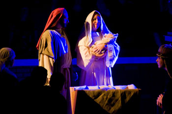 close up scene with blue LED light cast shadows of  a man dressed as Joseph with woman dressed as mary holding baby jesus in Journey to the Manger Musical - South Orlando Baptist Church, Orlando, FL, USA