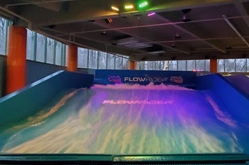 outdoor - indoor rated IP65 Techni-Lux DL-LEDPANEL36C/B fixtures illuminate the water wave in vibrant hues of purple magenta on the FlowRider Surf Machine, Splash Lagoon Indoor Water Park, Erie, Pennsylvania, USA