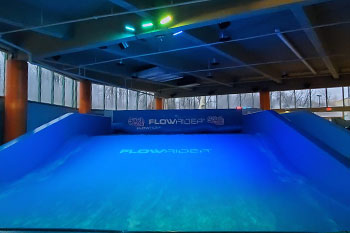 outdoor - indoor rated IP65 Techni-Lux DL-LEDPANEL36C/B fixtures illuminate the water wave in vibrant hues of blue green on the FlowRider Surf Machine, Splash Lagoon Indoor Water Park, Erie, Pennsylvania, USA