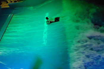 person surfing on illuminated water wave in vibrant hue of green on the FlowRider Surf Machine, Splash Lagoon Indoor Water Park, Erie, Pennsylvania, USA