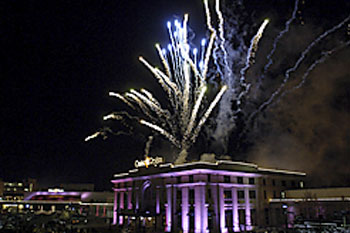 Casino Regina at night with purple architectural lights and fireworks in sky