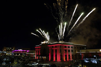 Casino Regina at night with purple architectural lights and fireworks in sky
