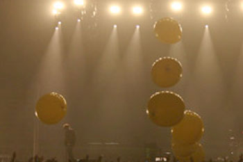 large inflated yellow balls being tossed around in the crowd during band Coldplay's Twisted Logic World Tour, United Kingdom