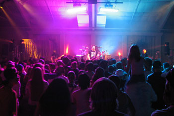 full crowd and illuminated stage in vibrant hues of blue, red and purple using SGM Ribalta, Palco 3 LED and Victory II 250 for the band Skillet concert New Creation Church, Colorado