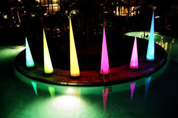 various sizes of LED lit cones in colors of blue, green, yellow and red around a pool - Airstar America rental for hotel - Orlando, Florida US
