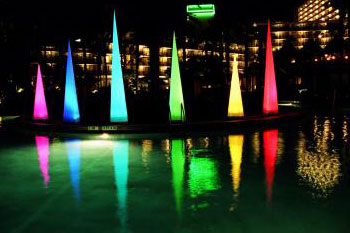 various sizes of LED lit cones in colors of red, yellow, green, aqua, blue and pink around a pool - Airstar America rental for hotel - Orlando, Florida US