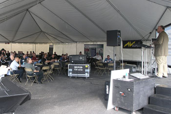 outside tent with guests sitting at tables listening to a guest speaker on stage at the Rental & Staging Roadshow 2008, Hosted by Techni-Lux, Orlando, Florida USA