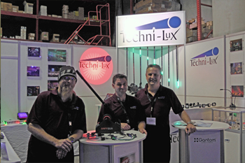 Techni-Lux staff Felix Gallardo in sales, Bruce McCalvin in tech dept and Alex Gonzalez VP at Techni-Lux booth, Technology Day 2018, Orlando, Florida USA