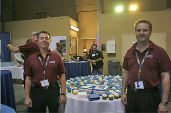 President Luciano Salvati and Vice President Alex Gonzalez in front of 20th sheet cake and cupcakes on table for the 20th Anniversary Open House 2010, Orlando, Florida USA