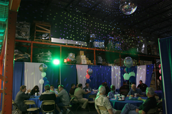 guest eating lunch under a lit mirrorball in the warehouse atTechni-Lux 20th Anniversary Open House 2010, Orlando, Florida USA