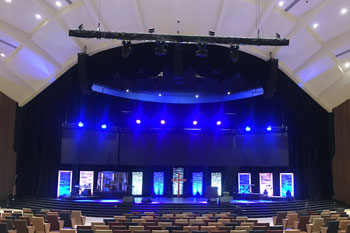 vibrant colors of blues as architectural wash from LED fixtures illuminated on the stage, UltraLED DMX Tricolor Bar inside Calvary Orlando building - Winter Park, FL, USA
