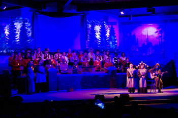 evening twilight scene with church backdrop with red/white hues of blues, cast over the  singers dressed as monk on stage - Journey to the Manger Musical - South Orlando Baptist Church, Orlando, FL, USA