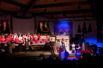 evening scene created SGM Palco 3 with blue LEDs with a man singing to children and a woman holding a baby gas station set man singing - Journey to the Manger Musical - South Orlando Baptist Church, Orlando, FL, USA
