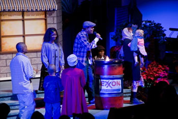 evening scene created SGM Palco 3 with blue LEDs with a man singing to children and a woman holding a baby gas station set man singing - Journey to the Manger Musical - South Orlando Baptist Church, Orlando, FL, USA