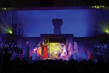 SGM Giotto fixtures with yellow LED beams projecting geometric circles above the stage and on live nativity on baby Jesus and the holy family, above the manger SGM Palco 3 fixtures blue light on backdrop with angel silhouette, Southpointe, Leesburg, FL, USA