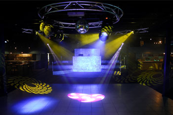 dance floor with disco ball, 4 yellow beams of light projecting geometric swirl of lines gobos, and red and white beams of light projecting swirl pattern gobos from Techni-Lux Trackers  Aqua Lounge, Daytona Beach, Florida
