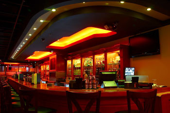 bar illuminated with recess LEDs fixtures in hues of oranges, reds and white inside The Vue Lounge - Clearmont, Florida, USA
