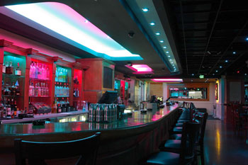 bar illuminated with recess LEDs fixtures in hues of reds and greens inside The Vue Lounge - Clearmont, Florida, USA
