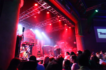 crowd waiting for band in front of stage with beams of white and red LED lights on stage and crowd at The Beacham - Orlando, Florida, USA