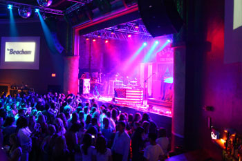  crowd gathered watching concert on stage screen in the background says The Beacham on corner of stage, lights on stage blue and magenta beams of LED and blue beams on the crowd and onThe Beacham - Orlando, Florida, USA