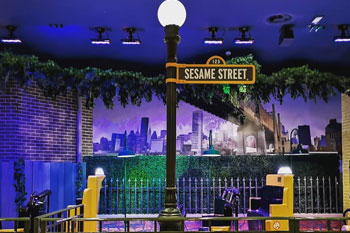 ride loading area lit with Techni-Lux LEDpanel 36 color LEDs back yard scene with new york in the background mural Sesame Street: Street Mission dark ride - PortAventura World, Salou, Spain