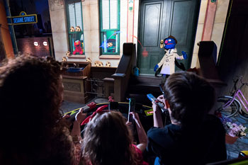 scene with guests riding by apartment building and characters from Sesame Street: Street Mission dark ride - PortAventura World, Salou, Spain