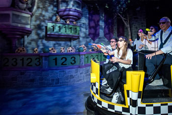 scene in a castle with numbers being lit by a foliage gobo pattern while guests ride along in a round yellow with black and white checker style taxi on Sesame Street: Street Mission dark ride - PortAventura World, Salou, Spain