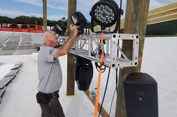 techni-lux in-house lighting designer adjust LED fixture on truss on Snow Slopes at Snowcat Ridge Alpine Snow Park - Dade City, Florida, USA