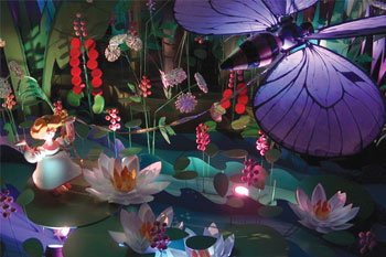 brightly painted scene from Hans Christian Andersen fairy tale thumbelina with an illuminated purple butterfly and white light accents on a pond with waterlilies, red flowers and thumbelina, The Flying Trunk Dark Ride, Tivoli Gardens - Copenhagen, Denmark