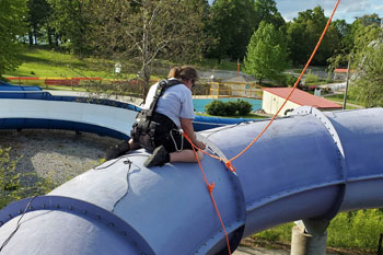 techni-lux in-house field technician lisa hansen harnessd and tethered to rope on one of the Waloopas Water Slides installing led fixutures at Venture River Water, Eddyville, Kentucky, USA