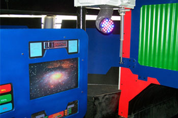 monitor with a black hole and star clusters bright neon orange, blue futuristic panels with buttons in the water ride loading area vibrant color dots Studio Due D-Color (show robots) Black Hole Water Slide, Wet 'n Wild - Orlando, Florida, USA