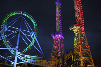 Goliath Coaster Thrill Ride illuminated at night with vibrant colors of purple pink, blue green and red yellow by Studio Due CityColor 2000 architecural lighting fixture, Six Flags New England - Agawam, Massachusetts, USA