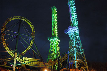 Goliath Coaster Thrill Ride illuminated at night with vibrant colors of purple, green and yellow by Studio Due CityColor 2000 architecural lighting fixture, Six Flags New England - Agawam, Massachusetts, USA