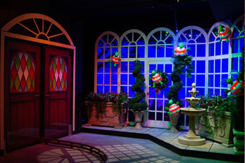 illuminated gobo with window pattersn on ground with green humbugs flying around in Scrooge's conservatory on the topiaries and windows with illuminated night hue of dark electri blue interior scene of The Great Humbug Adventure Dark Ride - Santa's Village, Jefferson, New Hampshire, USA 