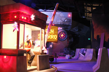  booth with man infected by Starro with red LEDs, in the background rosco geometric gobos, Join Starro street sign, Starro ship Justice League: Alien Invasion Warner Bros. Movie World - Gold Coast, Australia