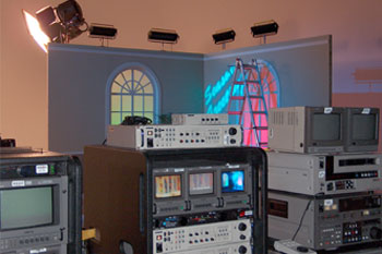 television equipement showing the different sets in front of a partial interior room set and windows with yellow and red LED wash for sky using SGM Palco 3 fixtures, ladder being used to adjust fixtures on set for Central Florida Jerry Lewis Labor Day Telethon - Orlando, Florida, USA